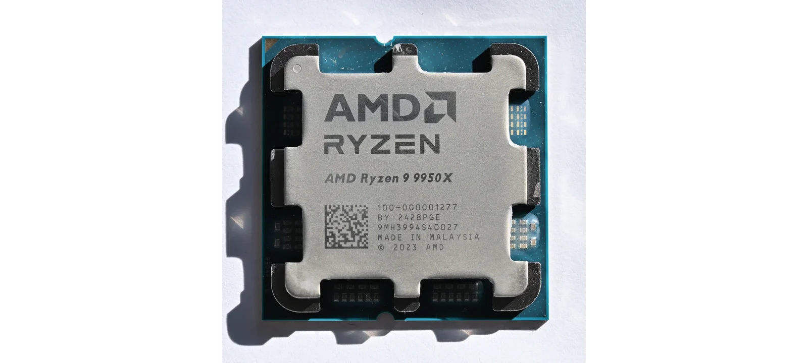 白い背景の上に置かれたAMD Ryzen 9 9950Xの実物CPU